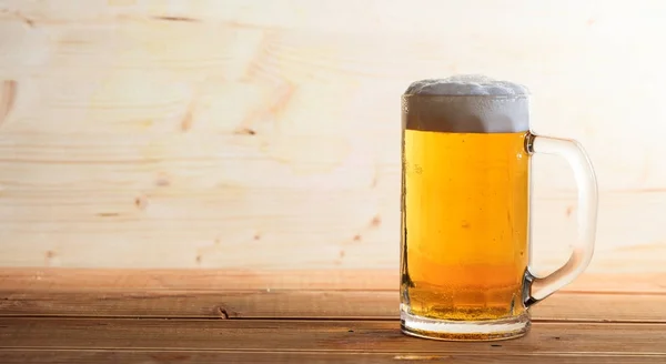 Um copo de cerveja em uma mesa de madeira, espaço de cópia — Fotografia de Stock