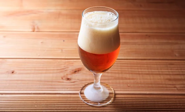 Un bicchiere di birra rossa su un tavolo di legno — Foto Stock