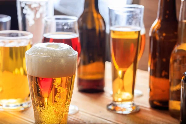 Un bancone da pub in legno, concentrati su un bicchiere di birra ghiacciato — Foto Stock