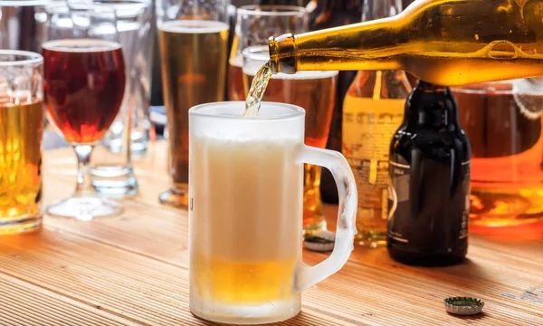 Derramando cerveja em uma caneca de cerveja em um fundo de pub — Fotografia de Stock