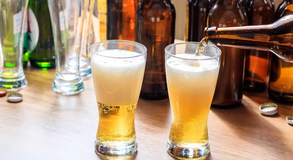 Versare la birra in un bicchiere di birra su uno sfondo pub — Foto Stock