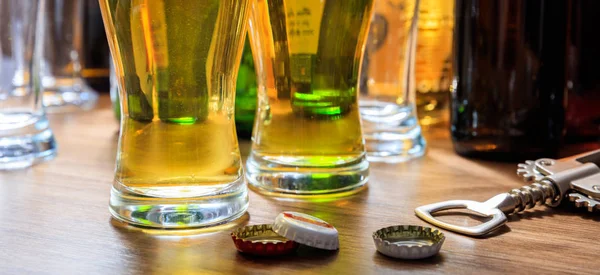 Пивные шапки и бокалы пива на фоне паба — стоковое фото