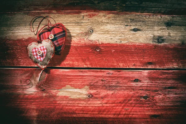 Corazones decorativos sobre fondo rojo de madera — Foto de Stock