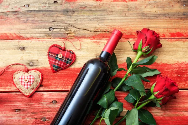 Saint Valentin. Bouteille de vin rouge et roses rouges sur fond en bois — Photo