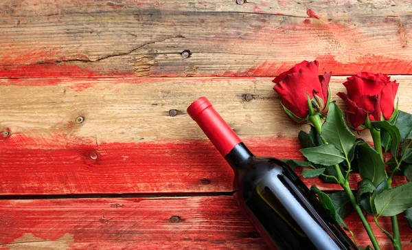 Dia dos Namorados. Garrafa de vinho tinto e rosas vermelhas no fundo de madeira — Fotografia de Stock