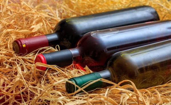 Weinflaschen auf Stroh Hintergrund — Stockfoto