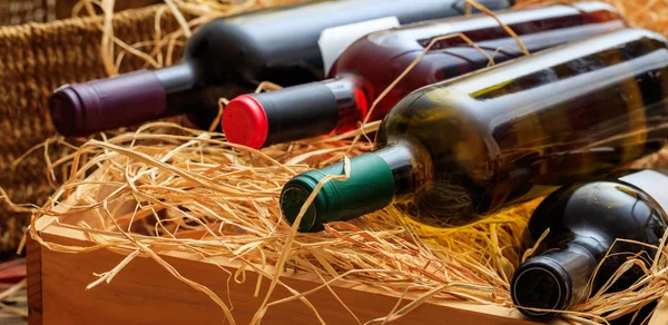Botellas de vino sobre fondo de paja — Foto de Stock