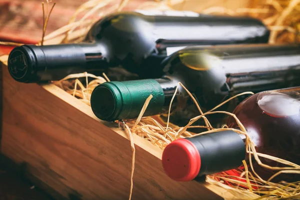 Wine bottles on straw background — Stock Photo, Image