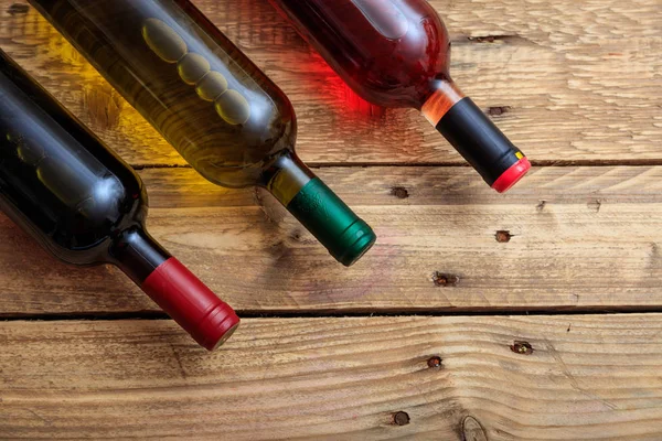 Bottiglie di vino su sfondo di legno, vista dall'alto, spazio copia — Foto Stock
