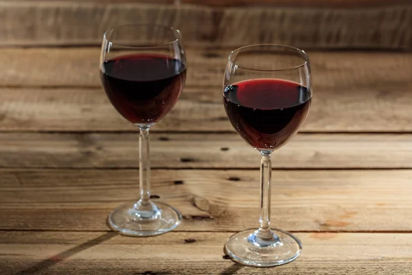 Red wine glasses on wooden background — Stock Photo, Image