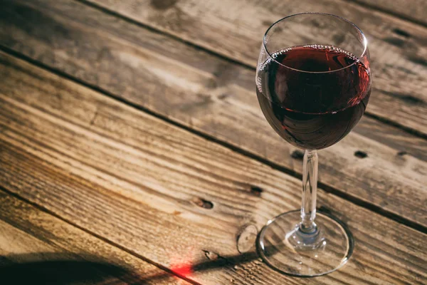 Bicchiere di vino rosso su sfondo di legno — Foto Stock