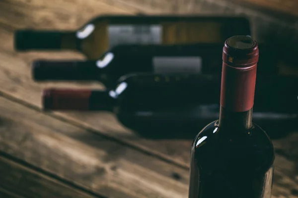 Красная бутылка вина на деревянном фоне — стоковое фото