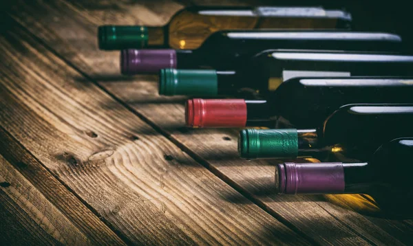 Бутылки вина на деревянном фоне — стоковое фото