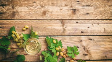 Beyaz şarap cam ve ahşap zemin, kopya alanı üzerine taze üzüm