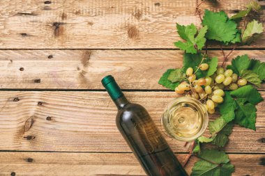 Beyaz Şarap kadehi ve şişe ve ahşap zemin, kopya alanı üzerine taze üzüm
