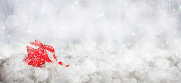 Estrella roja en Navidad fondo bokeh nevado —  Fotos de Stock