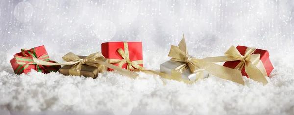 Red Christmas geschenkdozen op Kerstmis besneeuwde bokeh achtergrond — Stockfoto