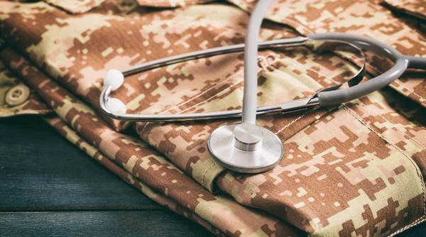 American military digital pattern uniform and stethoscope on wooden background — Stock Photo, Image