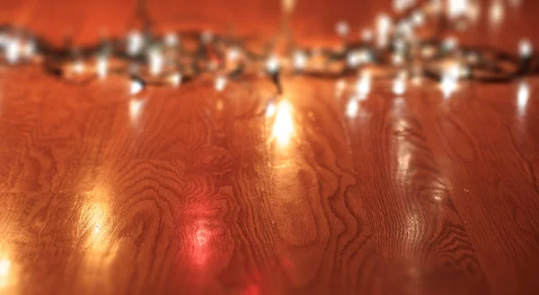 Weihnachtsbeleuchtung auf Holzboden verschwimmen lassen, Raum kopieren — Stockfoto