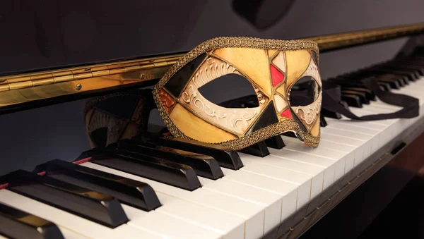 Carnival mask on classical piano keyboard