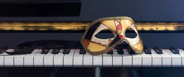 Maschera di Carnevale sulla tastiera del pianoforte, vista frontale — Foto Stock