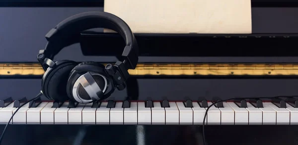 Kopfhörer auf Klaviertastatur, Frontansicht — Stockfoto