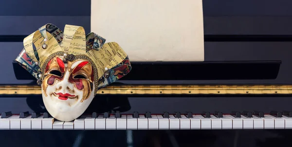Maschera di Carnevale sulla tastiera del pianoforte, vista frontale — Foto Stock