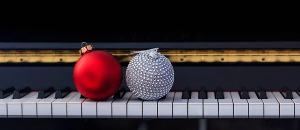 Palle rosse di Natale sulla tastiera del pianoforte, vista frontale — Foto Stock