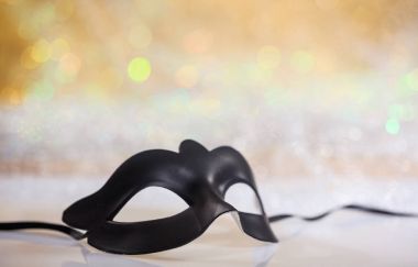 Bokeh arka plan üzerinde siyah karnaval maskesi
