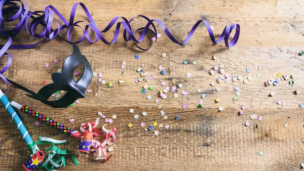 Carnaval partij. Masker, confetti en serpentines op houten achtergrond, top niew — Stockfoto