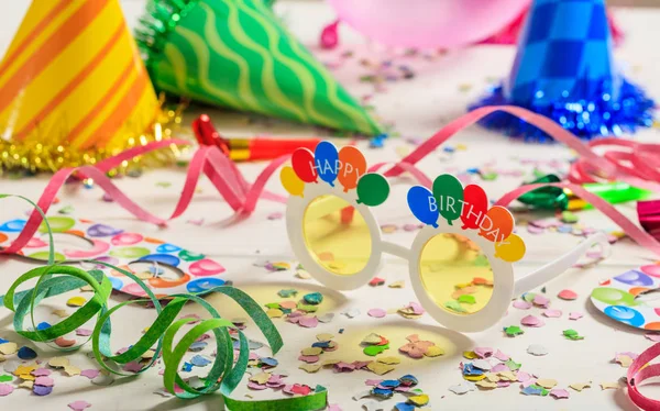 Birthday party. Confetti and serpentines on wooden background