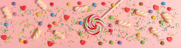 Bunte Bonbons auf rosa Hintergrund, Ansicht von oben — Stockfoto
