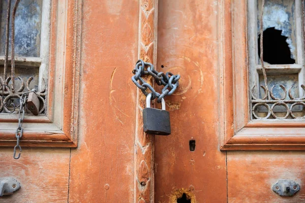 Cadenas rouillé sur une vieille porte en bois avec fenêtre cassée. Vue rapprochée avec détails . — Photo