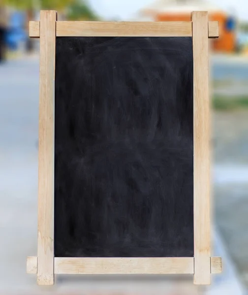 Cadre en bois avec tableau noir vide à l'intérieur et fond flou, espace pour le texte . — Photo