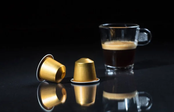 Espresso capsules and coffee cup on black background, Closeup view with details — Stock Photo, Image