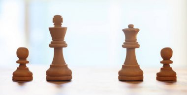 Satranç taşları kahverengi renk ışık. Kral, Kraliçe, piyonlar ayrıntılarla görünümünü kapatın. Arka plan bulanıklık.