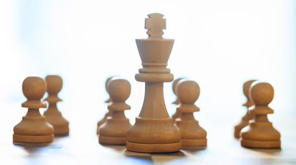 Schachfiguren hellbraune Farbe. Nahaufnahme von König und Bauern mit Details. verschwommener Hintergrund. — Stockfoto