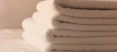 Otel yatak odası. Beyaz kabarık, katlanmış havlu, çarşaf çarşaf ve yastık yatak. Görünümü kapatın.