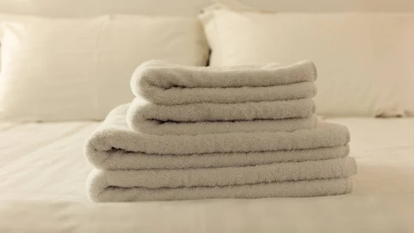 호텔 침실입니다. 솜 털, 백색 수건, 리넨 시트와 베개 침대에 접혀. 보기 닫기. — 스톡 사진