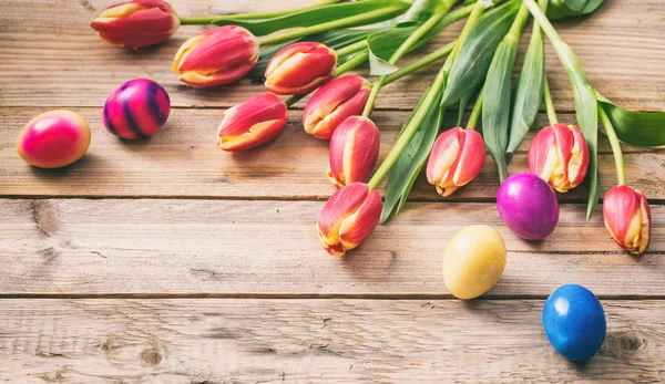 Ovos de Páscoa e tulipas frescas em fundo de madeira, espaço de cópia — Fotografia de Stock