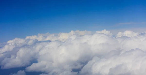 Wolken am strahlend blauen Himmel, Blick aus dem Flugzeugfenster — Stockfoto
