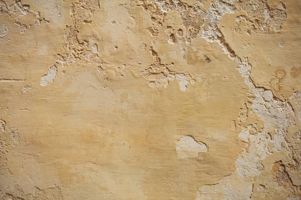 Pintado amarelo desgastado parede fundo, parcialmente desbotada — Fotografia de Stock