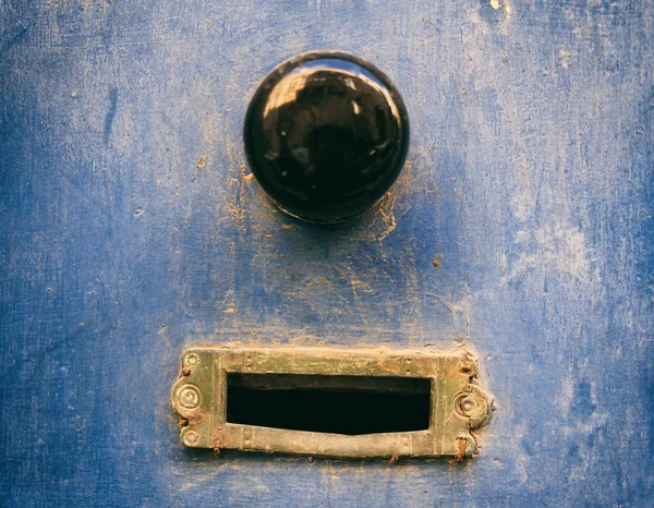 Oude koperen mail brievenbus en zwarte knop op een blauw geschilderde voordeur — Stockfoto