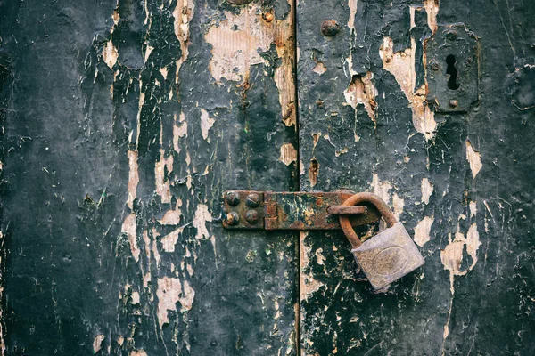 Κλειδωμένη πόρτα. Κλειστό το παλιό σκουριασμένο λουκέτο σε αναξιοπαθούντα ξύλινη πόρτα — Φωτογραφία Αρχείου