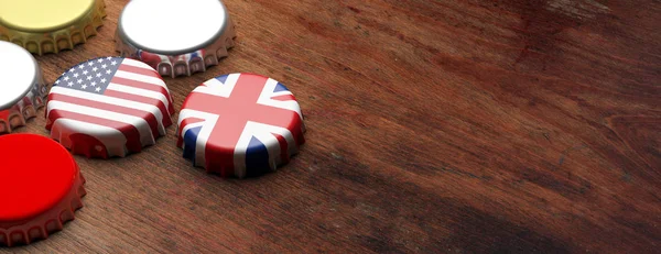 Beer caps with UK and USA flags on wooden background, copy space, banner. 3d illustration — Stock Photo, Image