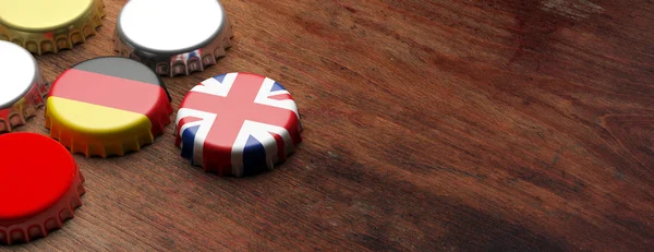 Beer caps with UK and Germany flags on wooden background, copy space, banner. 3d illustration