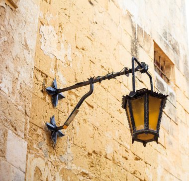 Malta, Mdina. Ortaçağ kentin dar sokakları ve evler kireçtaşı duvarları ile eski fener lambası