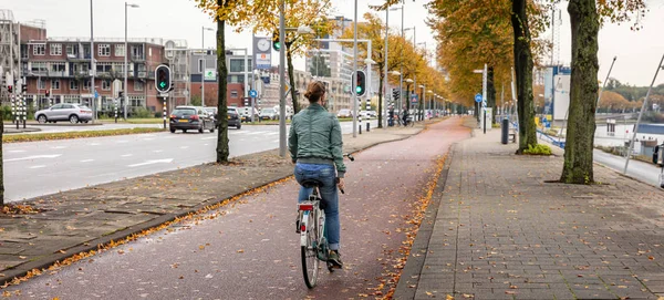 View of a woman riding a bicycle, Rotterdam Netherlands. — Stock Photo, Image