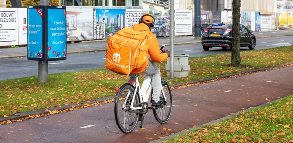 View of a food delivery man riding a bicycle, Rotterdam Netherlands. — Stock Photo, Image