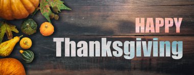 Mutlu Şükran Günü düzlüğü rengarenk balkabaklarıyla ve kırsal ahşap arka planda meyvelerle